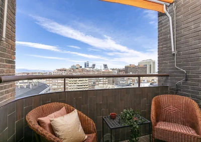 Imagen de la terraza después del Home Staging, utilizando materiales reutilizados de la vivienda, con una fotografía que captura las vistas panorámicas del skyline de Madrid desde la planta alta.