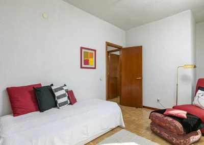 Imagen de un dormitorio individual después del Home Staging, con textiles y cojines modernos que combinan con el color de la butaca, creando un ambiente fresco y atractivo.